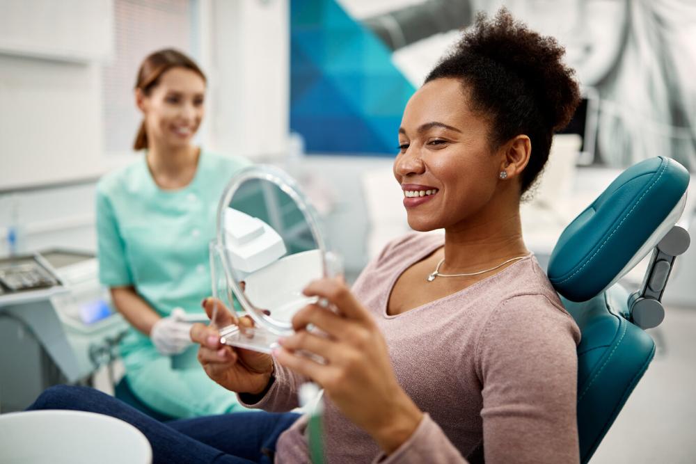 anderson woman looking at smile while sitting in a dental chair