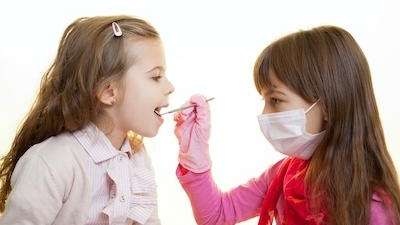 two young girls pretending to be dentists